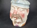a ceramic figurine of a man with a mustache and a beret