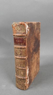 an old book sitting on top of a table next to a gray background
