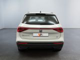 the rear end of a white suv parked in a room