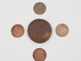 a group of five different coins sitting on top of a white surface