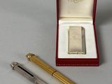 a pen and a lighter in a box on a table