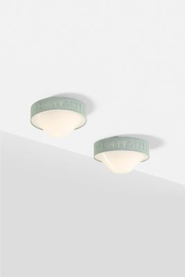 two light fixtures on the ceiling of a room with white walls