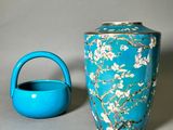 a blue vase and a teapot sitting on a table