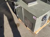 a small air conditioner sitting on a pallet next to a building