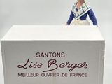 a figurine of a woman standing behind a box