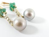pair of pearl and emerald earrings on a white surface