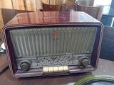 an old radio sitting on a table next to a speaker
