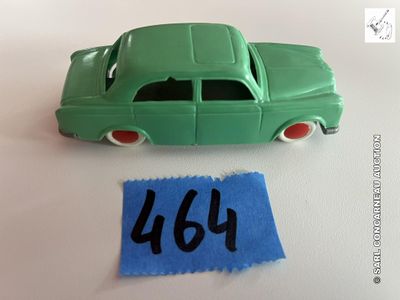 une petite voiture verte à côté d'une feuille de papier bleue