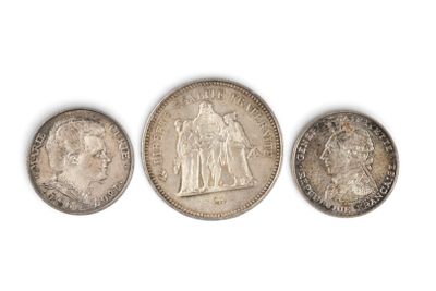 trois types différents de pièces d'argent sur une surface blanche