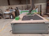 a machine that is cutting a piece of wood on a table