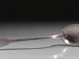 une cuillère et un repose-cuillère sur une surface blanche