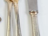 a lot of silverware on a table with a knife and fork