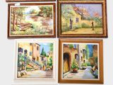 several framed paintings of different types and sizes hang on a wall