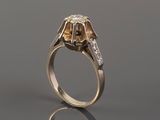 a gold and diamond ring with two diamonds on the side