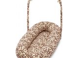 a brown and white dog bed in a basket on a white background