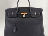 a black leather handbag with a gold lock on it