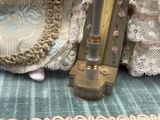 une horloge dorée et argentée posée sur une table recouverte d'une nappe bleue