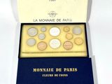 une boîte remplie de pièces posée sur une table, sur laquelle est collée une étiquette