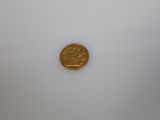 a close up of a gold coin on a white surface
