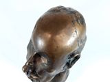 a bronze sculpture of a baby head on a white background