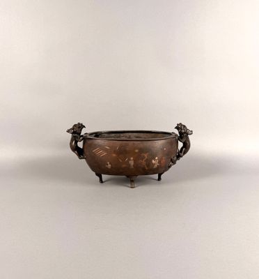 un bol ancien en bronze, muni de deux anses et orné de deux oiseaux de chaque côté