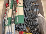 une boîte remplie de rails de train miniature et d'autres petits trains