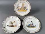 three plates with different designs on them sitting on a table