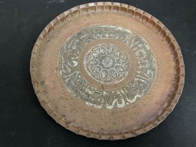 une assiette marron ornée d'un motif, posée sur une table