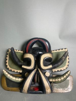 l'image d'un masque en bois orné de cornes