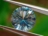 un diamant bleu maintenu par une paire de pinces