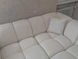 a large white couch sitting in a living room next to a radiator