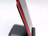 a red and black cell phone on a stand