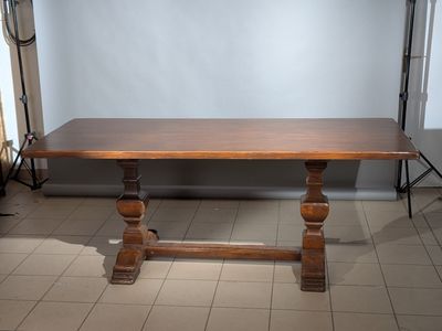 une grande table en bois qui se trouve au milieu d'une pièce