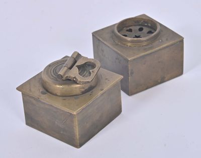 two small metal objects that are sitting on a white surface