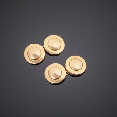 three gold plated buttons on a black surface