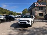 une voiture blanche garée devant un bâtiment dans un parking