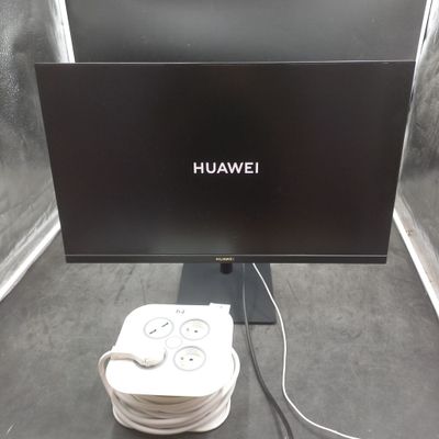 un écran d'ordinateur et un chargeur posés sur une table
