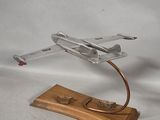 a small model of a fighter jet on a wooden stand