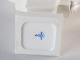 a small white plate with a blue fish on it