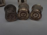 three silver pepper shakers sitting next to each other on a table