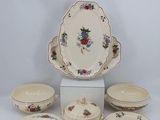 a white table with a bunch of plates and bowls on it