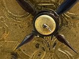 a gold clock that is on display in a room