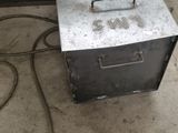 a small metal box sitting on the floor next to a chair
