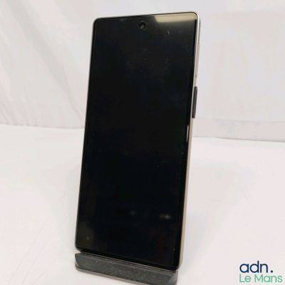 the back of a black cell phone sitting on top of a white table