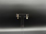 gros plan d'une paire de boucles d'oreilles sur un support