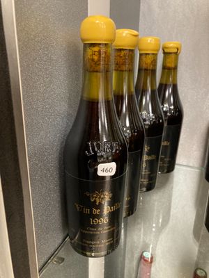 Plusieurs bouteilles de vin sont alignées sur une étagère en verre