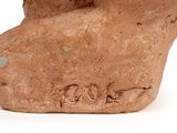 a clay sculpture of a bird on a white surface