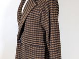 the coat is brown and black houndsered on a mannequin stand