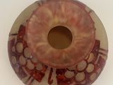la photo d'un vase brun et rouge troué