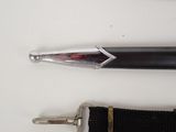 a black pen and a silver pen on a white table